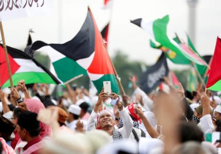 A protester takes a picture with his handphone during a rally to condemn U.S. President Donald Trumps's decision to recognise Jerusalem as Israel's capital, at Monas, the national monument, in Jakarta, Indonesia, December 17, 2017. REUTERS/Darren Whiteside