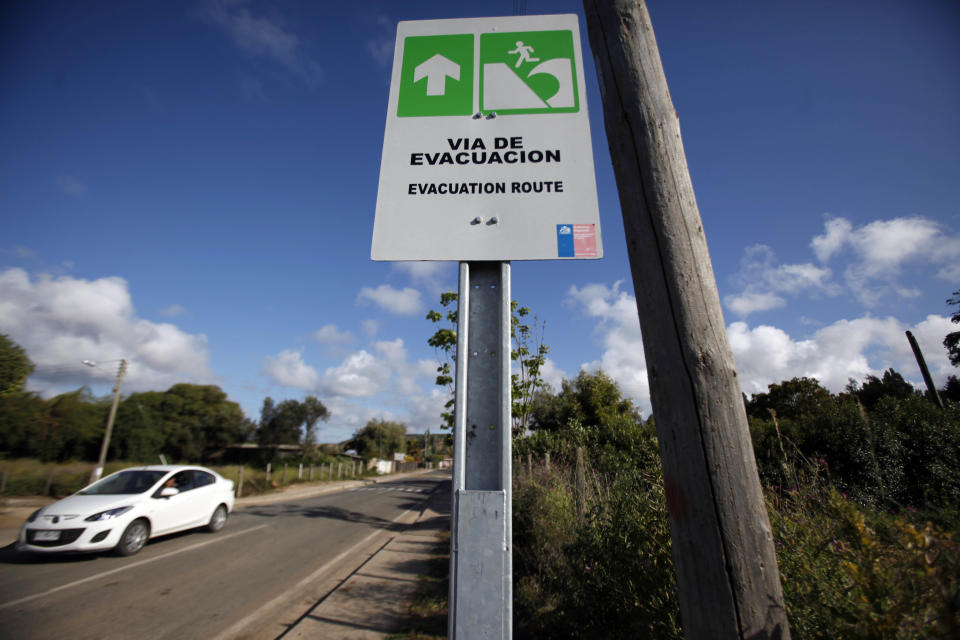 FILE - In this Nov. 29, 2012, file photo, a car drives by a sign indicating the evacuation route in the event of a tsunami, in Navidad, Chile. A strong magnitude-6.7 earthquake off Chile’s far-northern coast on March 16. 2014, caused more than 100,000 people to briefly evacuate low-lying areas and has been followed by an unsettling string of more than 300 aftershocks. Chile is one of the world's most earthquake-prone countries. (AP Photo/Luis Hidalgo, File)