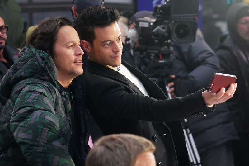 Actor Rami Malek takes a selfie with director Cary Joji Fukunaga during a promotional appearance on TV in Times Square for the new James Bond movie "No Time to Die" in the Manhattan borough of New York City