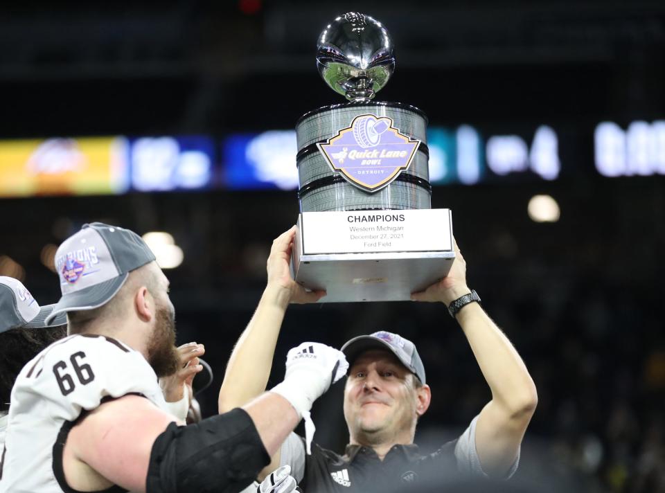 Western Michigan head coach Tim Lester accepts the  Quick Lane Bowl trophy after the Broncos' 52-24 win over Nevada on Monday, Dec. 27, 2021, at Ford Field.