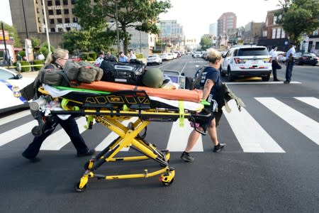 Paramedics roll a stretcher near the scene of a shooting incident in which several police were injured in Philadelphia
