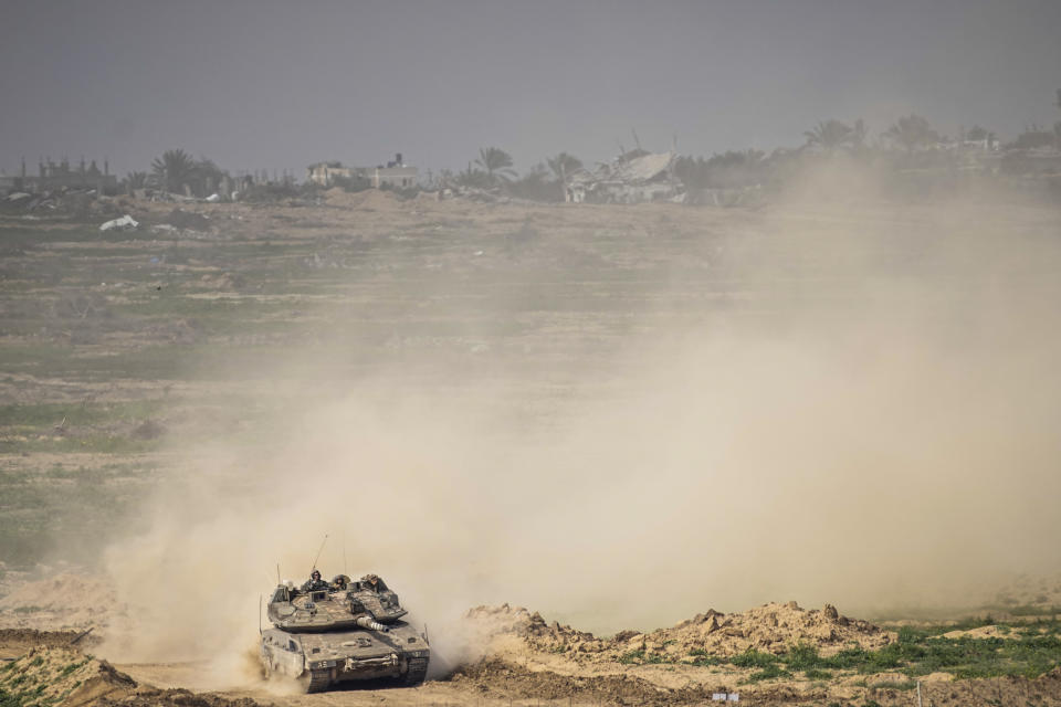 Israeli soldiers drive a tank inside Gaza Strip, as seen from southern Israel, Tuesday, Feb. 13, 2024. The army is battling Palestinian militants across Gaza in the war ignited by Hamas' Oct. 7 attack into Israel. (AP Photo/Ariel Schalit)