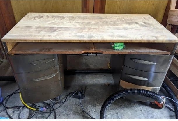 A before image of a desk with dark refinishing sanded down to reveal light wood
