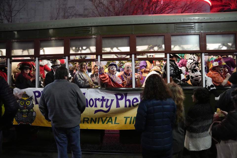 Members of the Mardi Gras group The Phunny Phorty Phellows revel on a street car for their annual kick off of the Mardi Gras season on Twelfth Night in New Orleans, Friday, Jan. 6, 2023. (AP Photo/Gerald Herbert)