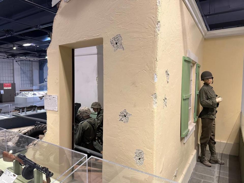 This display in the Curtis Earl Weapons Exhibit shows an American soldier sneaking up on German soldiers in a bombed-out European house. The bullet holes are authentic. Then-museum director Ken Swanson took the display items out to the desert and shot them with real bullets.
