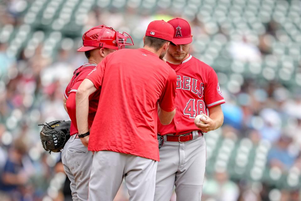 Anglels coach Matt Wise (center), pitcher Reid Detmers (right) and catcher Max Stassi meet at the mound during the bottom of the second inning at Comerica Park on Aug. 20, 2022 in Detroit.