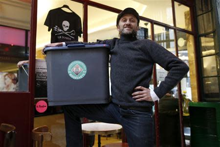 Stephan Martinez, owner of Le Petit Choiseuil bistrot, poses with a garbage container to collect food waste in Paris February 12, 2014. REUTERS/Charles Platiau