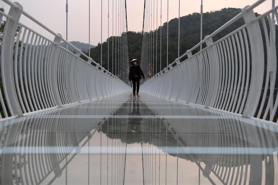 a person walks on the Bach Long glass bridge in the Moc Chau district in Vietnam's Son La province