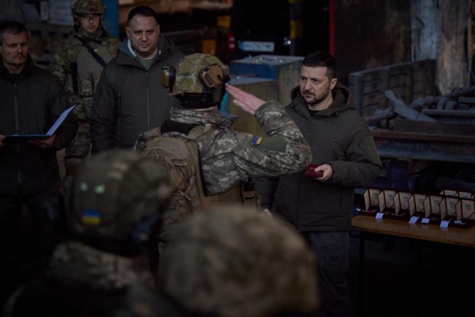 Ukrainian President Volodymyr Zelenskyy looks at a solider who is saluting him