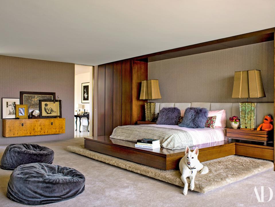 In the master bedroom, Dolly, one of the couple’s three dogs, lounges on the platform’s pashmina shag carpet. Custom walnut bed with suede headboard by Shadley.