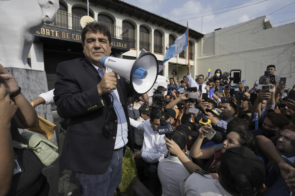 Presidential candidate Carlos Pineda of the Prosperidad Ciudadana party holds a bullhorn after arriving to the Constitutional Court in Guatemala City, Saturday, May 20, 2023. Pineda seeks to reverse a court decision that has excluded him from the electoral process. (AP Photo/Moises Castillo)