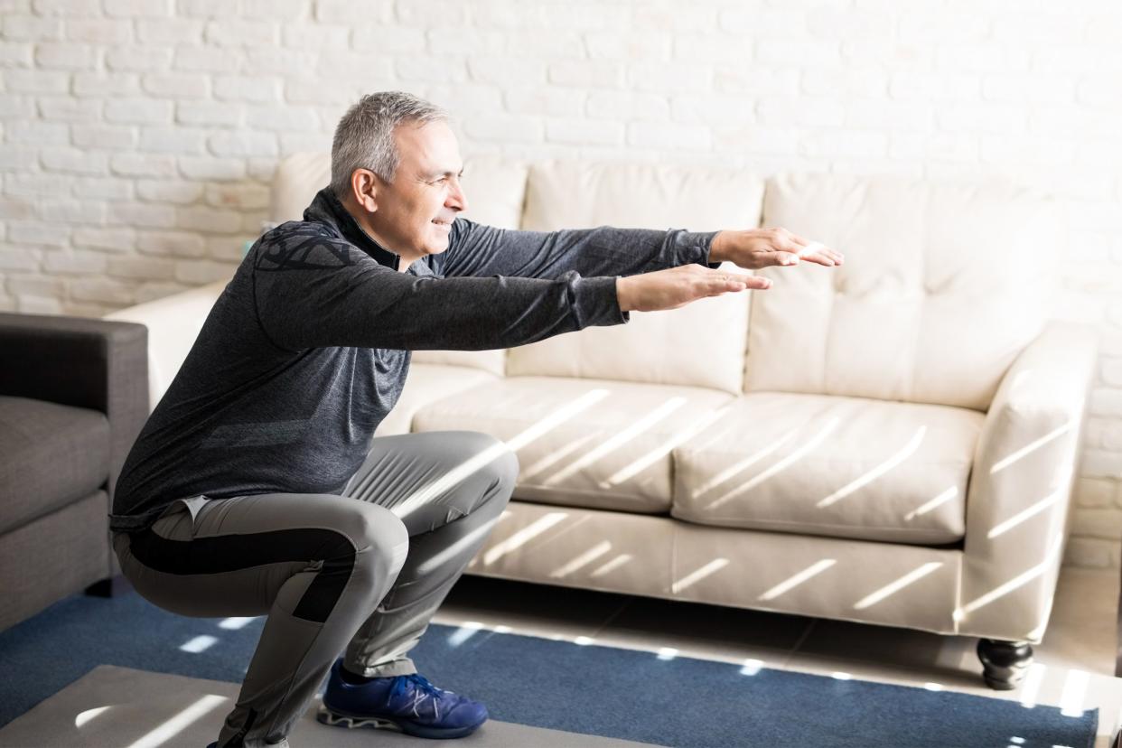 Man doing squats in his living room