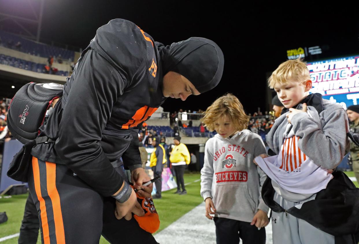 Massillon quarterback DaOne Owens signs autographs for young Tigers fans after winning the Division II state final, Nov. 30, 2023, in Canton.