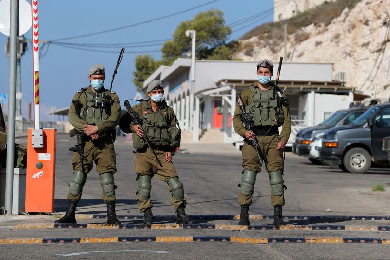 Israeli soldiers stand guard on the road leading to Rosh Hanikra border crossing with Lebanon, northern Israel