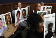 Family members of people who died in crashes of the Boeing 737 MAX hold photographs of their lost loved ones as FAA Administrator Stephen Dickson testifies during a House Transportation Committee hearing on the Boeing 737 MAX, Wednesday, Dec. 11, 2019, on Capitol Hill in Washington. (AP Photo/Jacquelyn Martin)