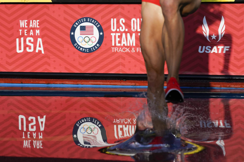 A runner enters the water in the first prelim of the women's 3000-meter steeplechase at the U.S. Olympic Track and Field Trials Sunday, June 20, 2021, in Eugene, Ore. (AP Photo/Ashley Landis)