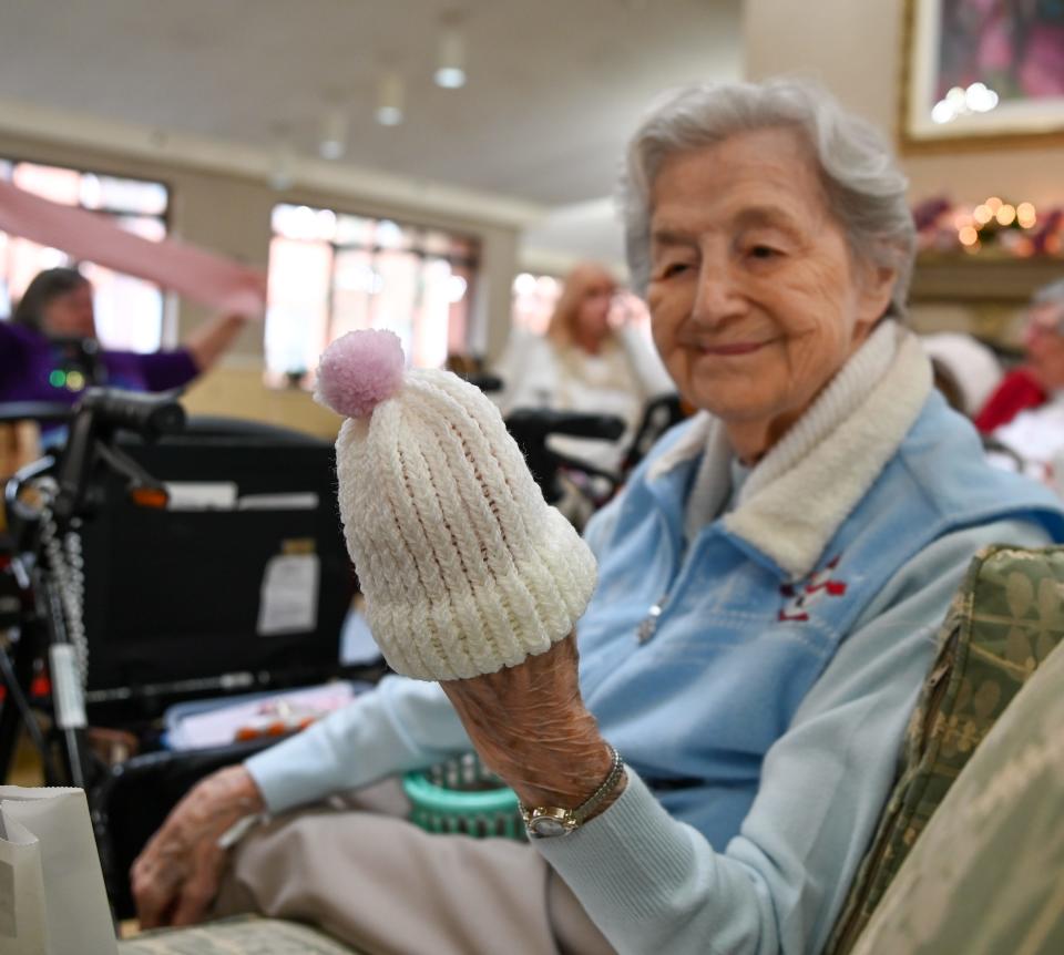Sandra Galasso admires a baby hat she finished knitting on Thursday, Dec. 15, 2022, in Independence Village of East Lansing.