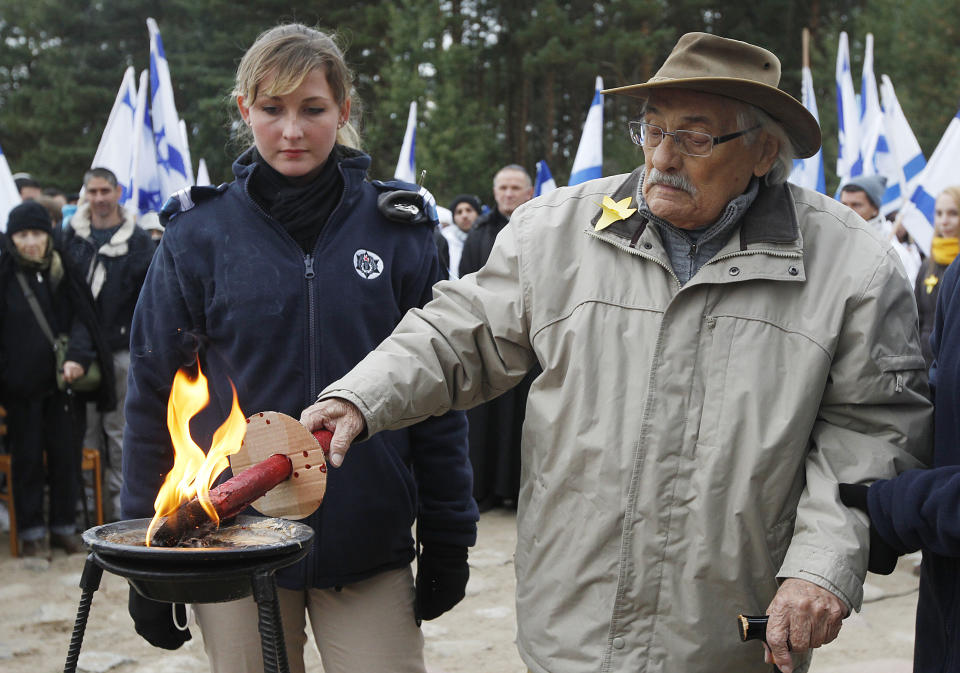 In this Wednesday, Oct. 2, 2013 photo the survivor of the Treblinka death camp, 90-year-old Samuel Willenberg, who died 2016, lights a candle at the monument to some 900,000 European Jews killed by the Nazis between 1941-1944 at the camp in Poland. Ada Krystyna Willenberg, the widow of one revolt fighter Samuel Willenberg, appealed Thursday for a proper museum to be built at the site of the former camp. The current memorial consists of boulders bearing the names of locations that the inmates came from. (AP Photo/Czarek Sokolowski, file)