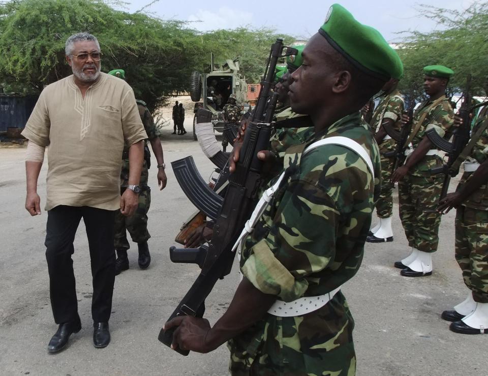 FILE - In this Wednesday, July 20, 2011 file photo, the African Union envoy to Somalia, Jerry Rawlings, inspects a guard of honour of African Union peacekeepers, during a visit to displaced persons camps in southern Mogadishu, Somalia. Ghana's former president Jerry Rawlings, who staged two coups and later led the West African country's transition to a stable democracy, has died aged 73, according to the state's Radio Ghana and the president Thursday, Nov. 12, 2020. (AP Photo/Farah Abdi Warsameh, File)