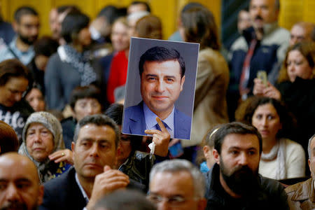 A supporter holds a portrait of Selahattin Demirtas, detained leader of Turkey's pro-Kurdish opposition Peoples' Democratic Party (HDP) at a meeting at the Turkish parliament in Ankara, Turkey, November 8, 2016, in the absence of Demirtas and other HDP lawmakers who were jailed after refusing to give testimony in a probe linked to "terrorist propaganda". REUTERS/Umit Bektas