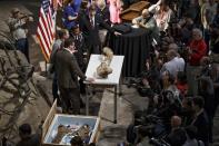 The fossilized bones of a Tyrannosaurus rex are displayed for the media during a ceremony at the Smithsonian Museum of Natural History in Washington, Tuesday, April 15, 2014. The Tyrannosaurus rex is joining the dinosaur fossil collection on the National Mall on Tuesday after a more than 2,000-mile journey from Montana. For the first time since its dinosaur hall opened in 1911, the Smithsonian's National Museum of Natural History will have a nearly complete T. rex skeleton. FedEx is delivering the dinosaur bones in a truck carrying 16 carefully packed crates. (AP Photo/J. Scott Applewhite)