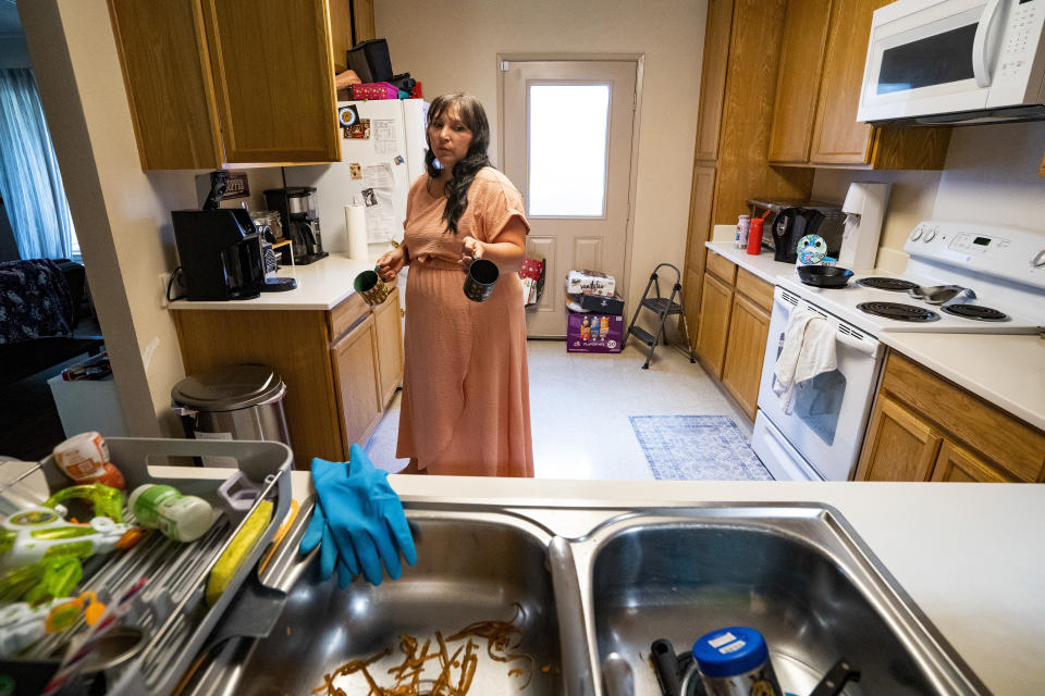 Richelle Dietz holds couple of mugs at her home, Monday, April 22, 2024, in Honolulu, Hawaii. Dietz plans to dispose of all their tableware as it was used with tainted tap water. (AP Photo/Mengshin Lin)