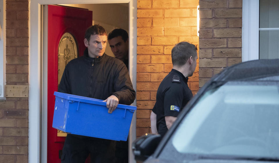 Police leave the home of Joanna and Thomas Maher with an evidence box at Wiltshire close in Warrington, Cheshire, Friday, Oct. 25, 2019, after a man and a woman, both aged 38 and from Warrington, have been arrested on suspicion of manslaughter and conspiracy to traffic people in connection with the 39 bodies found in a lorry in Essex on Wednesday. ( Jason Roberts/PA via AP)