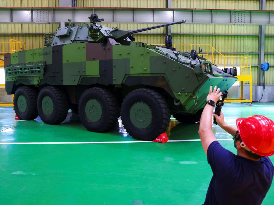 A member of the media takes photos of Taiwan military latest homemade armoured vehicle the CM-34 "Clouded Leopard" in Nantou