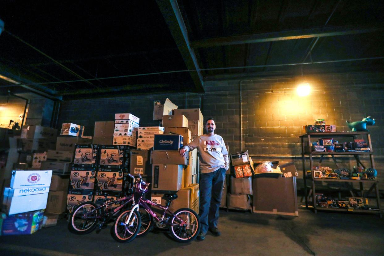Kevin Ryan, Team Rubicon's communications lead for Wisconsin, poses for a portrait in front of stacks of donated toys and children's items on Jan. 20, 2022. The disaster relief organization is managing donations for Afghan evacuees who are resettling in the Milwaukee area.