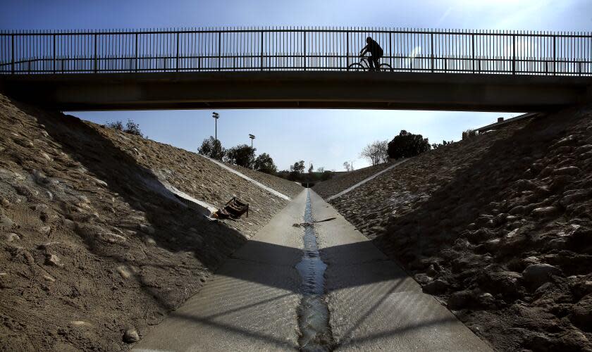 PACOIMA, CA-MARCH 21, 2014: A bicycle rider pedals across the Haddon Ave bridge located above the Pacoima Wash in Pacoima on March 21, 2014. City officials are considering ambitious plans to open up the area above the banks to the public, adding bike lanes and a "ribbon of green" to this densely-populated and park-poor area with high rates of obesity and health problems. (Mel Melcon/Los Angeles Times)