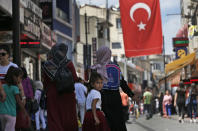 People walk at a market in Istanbul, Wednesday, Aug. 15, 2018. The Turkish lira currency has nosedived in value in the past week over concerns about Turkey's President Recep Tayyip Erdogan's economic policies and after the United States slapped sanctions on Turkey angered by the continued detention of an American pastor. (AP Photo/Lefteris Pitarakis)