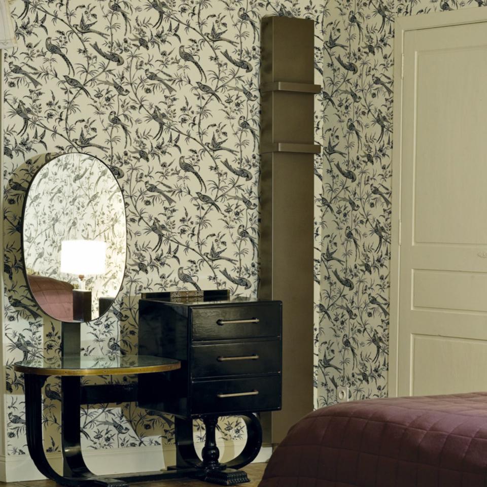 tall radiator in bedroom with patterend wallpaper and decorative vanity table