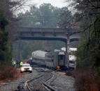 <p>Investigators make their way around the train wreckage under the Charleston Highway overpass in Cayce, SC where two trains collided early Sunday morning on Feb. 4, 2018. (Photo: Bob Leverone/Getty Images) </p>