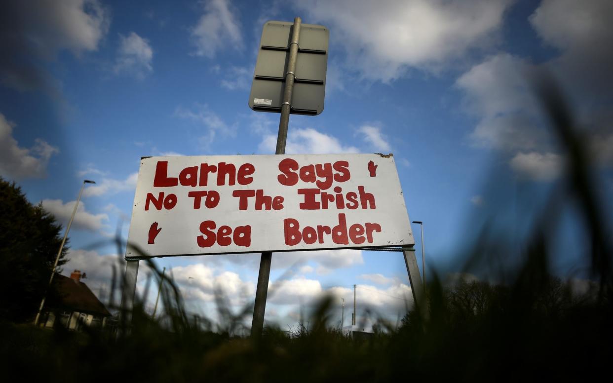 A sign with a message against the Brexit border checks in relation to the Northern Ireland protocol at the harbour in Larne - Clodagh Kilcyone/Reuters