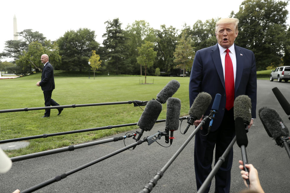 President Donald Trump speaks to members of the media on the South Lawn of the White House in Washington as FIFA president Gianni Infantino, left, walks away, Monday, Sept. 9, 2019, before boarding Marine One for a short trip to Andrews Air Force Base, Md., and then on to North Carolina. (AP Photo/Andrew Harnik)