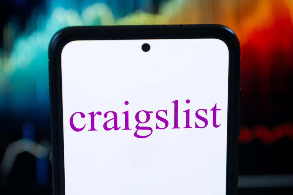 Smartphone displaying Craigslist logo on screen, held against a blurred background