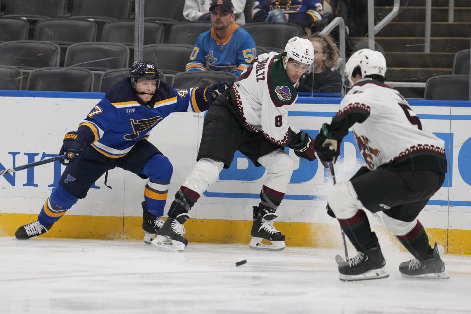 St. Louis Blues' Torey Krug, left, watches the puck as Arizona Coyotes' Nick Schmaltz (8) and Sean Durzi (50) defend during the second period of an NHL hockey game Thursday, Nov. 9, 2023, in St. Louis. (AP Photo/Jeff Roberson)