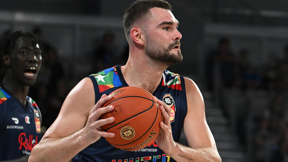 Melbourne United's Isaac Humphries looks to pass the ball during an NBL game.