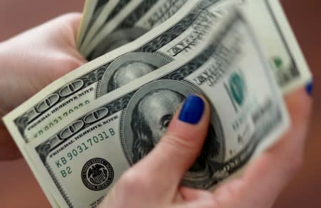 A woman counts U.S. dollar bills at her home in Buenos Aires