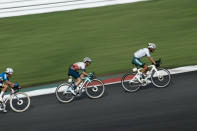 Simon Philip Yates of Great Britain, center, is seen in this slow shutter speed photo, comptes during the men's cycling road race at the 2020 Summer Olympics, Saturday, July 24, 2021, in Oyama, Japan. (AP Photo/Thibault Camus)