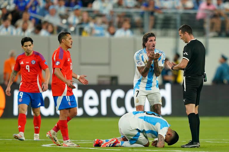 El reclamo de Rodrigo De Paul ante el árbitro uruguayo Andrés Matonte, tras una falta al Cuti Romero; Alexis Sánchez contempla la escena