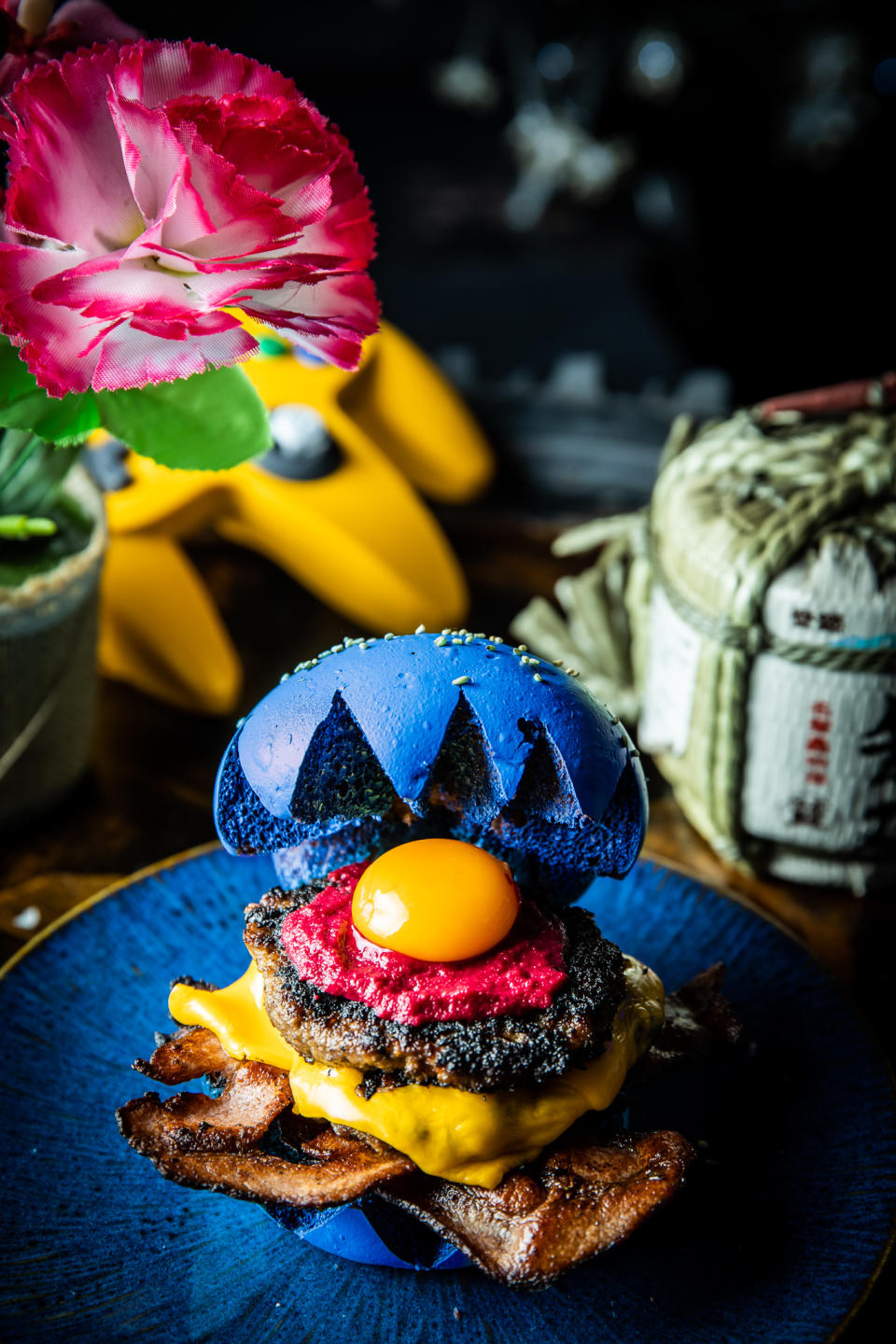 Involves a radical, highly classified, Blue Brioche bun recipe. The “Next Level” quarter pounder of freshly ground, seasoned and seared Wagyu beef, has special bonus rounds of Canadian maple streaky bacon and melted cheese. An egg yolk, beetroot mustard and relish, golden onion rings round out the burger. Game on! Photo: Supplied/@bosohq