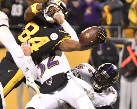 Dec 25, 2016; Pittsburgh, PA, USA; Pittsburgh Steelers wide receiver Antonio Brown (84) has his fasemask grabbed while he extends the ball across the goal line to score the game winning touchdown against Baltimore Ravens strong safety Eric Weddle (32) in the fourth quarter. The Steelers won 31-27 at Heinz Field. Mandatory Credit: Mark Konezny-USA TODAY Sports