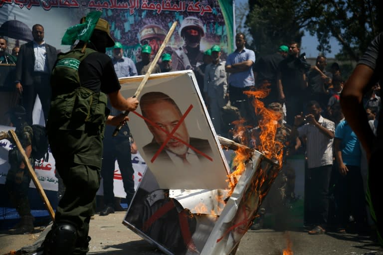 Palestinian supporters of the Islamist Hamas movement burn placards bearing pictures of Avigdor Lieberman, who is set to become Israel's minister of defence, during a rally in Gaza City