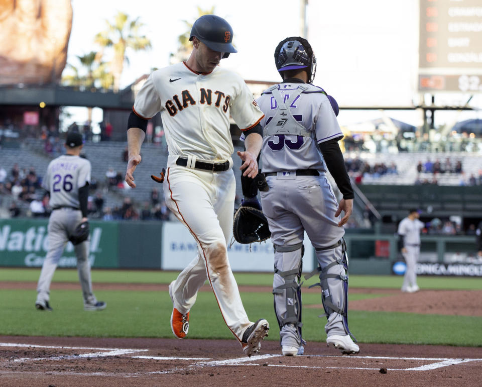 San Francisco Giants' Austin Slater, left, scores on a sacrifice fly by Mauricio Dubón (not shown) during the first inning of a baseball game against the Colorado Rockies, Monday, May 9, 2022, in San Francisco. (AP Photo/D. Ross Cameron)