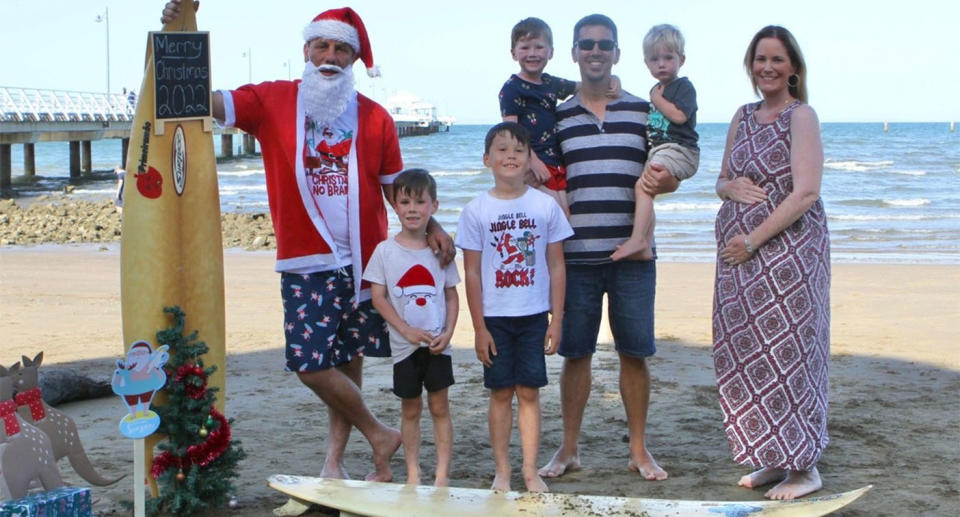 The Thompson family pose for a photo on the beach, as Lauren cradles her pregnant belly.