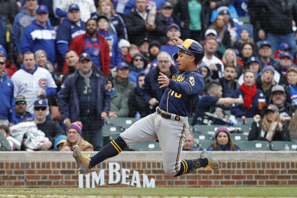 Milwaukee Brewers' Kolten Wong slides to score against the Chicago Cubs during the seventh inning of a baseball game, Thursday, April 7, 2022, in Chicago. (AP Photo/Kamil Krzaczynski)