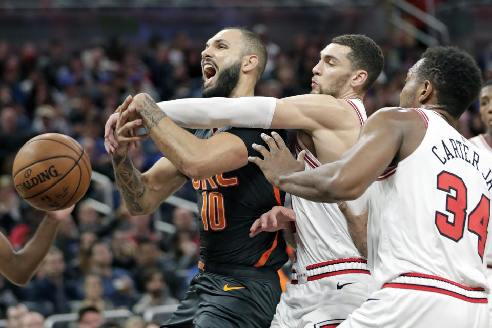 Orlando Magic guard Evan Fournier, left, is fouled as he goes up for a shot against Chicago Bulls guard Zach LaVine, center, and center Wendell Carter Jr. (34) during the second half of an NBA basketball game, Monday, Dec. 23, 2019, in Orlando, Fla. (AP Photo/John Raoux)