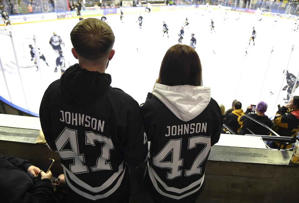 FILE - Nottingham Panthers fans wearing number 47, Adam Johnson's number, before the Ice Hockey Adam Johnson memorial game between Nottingham Panthers and Manchester Storm at the Motorpoint Arena, Nottingham, England, Saturday, Nov. 18, 2023. "Import” hockey players in the United Kingdom don't earn big salaries but the lifestyle and perks are pretty good. They get free use of a car and rent-free housing. These mostly Canadian and American imports are mini-celebrities around the Elite Ice Hockey League. They can also earn a master's degree tuition-free. Adam Johnson of the Nottingham Panthers was living with his fiancée and studying at a business school. (AP Photo/Rui Vieira, File)