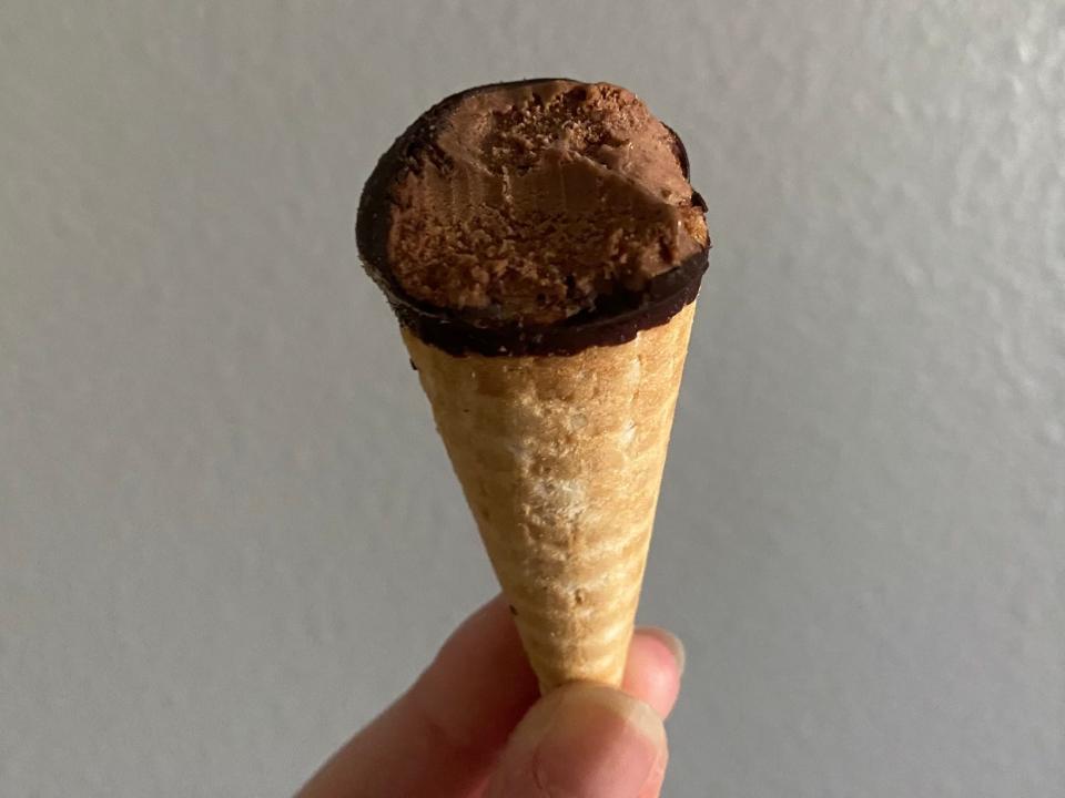 The writer holds a bitten chocolate Hold the Cone dessert